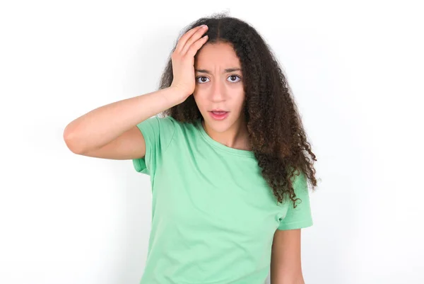 Embarrassed Teenager Girl Afro Hairstyle Wearing White Shirt Green Background — Stok fotoğraf