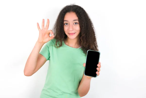 Teenager Girl Afro Hairstyle Wearing White Shirt Green Background Holding — Stockfoto
