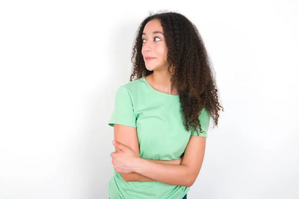 Pleased Teenager Girl Afro Hairstyle Wearing White Shirt Green Background — Stockfoto