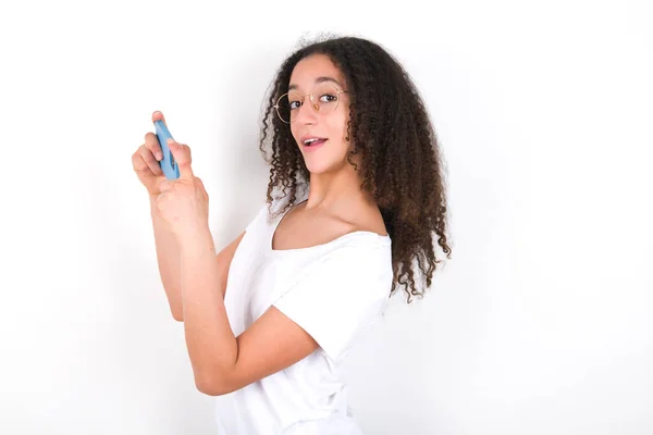 Nice Addicted Cheerful Teenager Girl Afro Hairstyle Wearing White Shirt — Foto de Stock