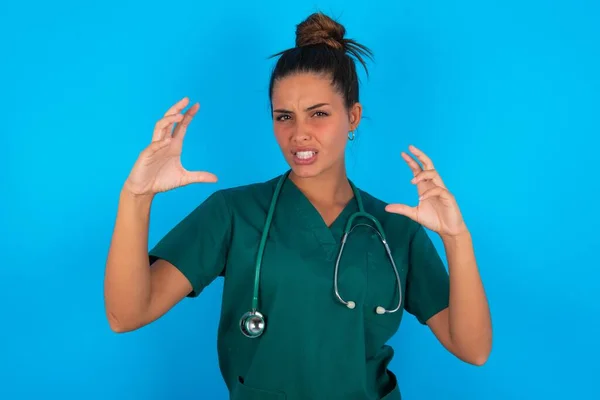 Hermosa Doctora Hispana Vistiendo Uniforme Médico Verde Sobre Fondo Azul — Foto de Stock