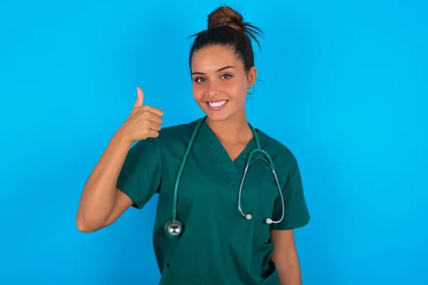 Mavi Arka Planda Yeşil Üniforma Giyen Güzel Spanyol Doktor Kadın — Stok fotoğraf