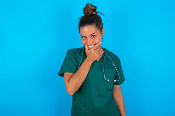 Piękna Latynoska Lekarka Ubrana Zielony Mundur Medyczny Niebieskim Tle Wyglądająca — Zdjęcie stockowe