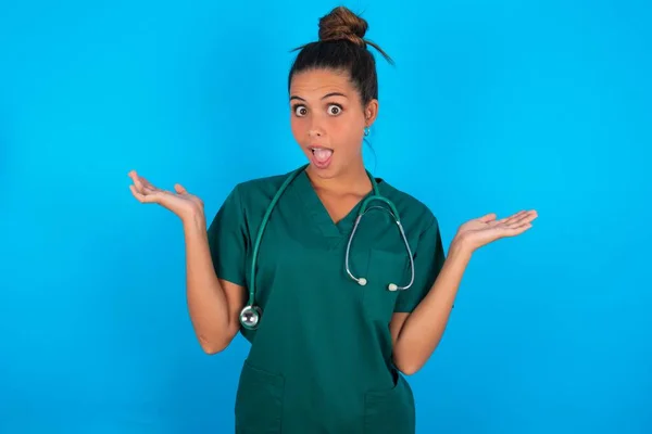 Hermosa Doctora Hispana Vistiendo Uniforme Médico Verde Sobre Fondo Azul — Foto de Stock