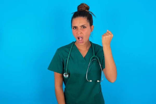 Hermosa Doctora Hispana Vistiendo Uniforme Médico Verde Sobre Fondo Azul — Foto de Stock