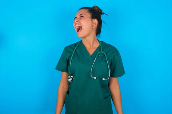Bela Doutora Mulher Vestindo Uniforme Médico Sobre Fundo Azul Irritado — Fotografia de Stock