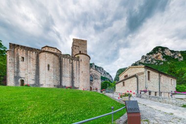 San Vittore Frasassi, Marche, İtalya 'daki ortaçağ köyü üzerinde dramatik bir gökyüzü. Romantik gökyüzü ve dağların üzerindeki bulutlar manzara, turizm beldesi.