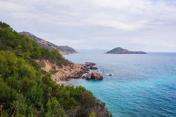 Kışın Tuscany, İtalya 'da Rocky kıyı şeridi ve su körfezi. Monte Argentario doğal parkı dramatik gökyüzü ormanı Akdeniz mavi suyu.