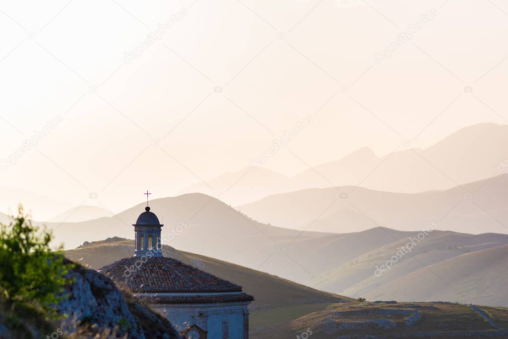 Castle ruins and small chapel at Rocca Calascio italian travel destination, landmark in the Gran Sasso National Park, Abruzzo, Italy. Clear blue sky