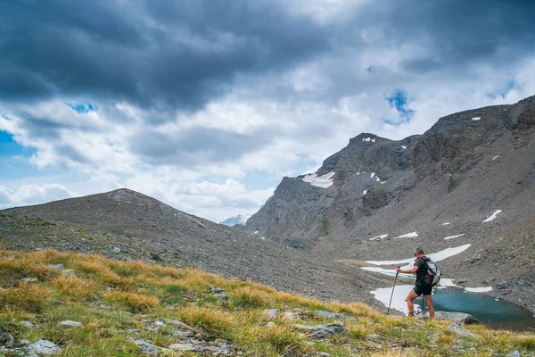 徒步旅行者俯瞰高山上的田园诗般的蓝色高山湖 高山上的风景秀丽的岩石地形 健身自由的理念 — 图库照片