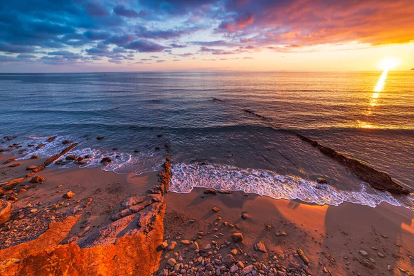 Sanremo Riviera Dei Fiori Liguria Italy 海滩上的岩石和卵石在夕阳西下闪烁着美丽的光芒 戏剧化的五彩斑斓的天空摇曳着大海 — 图库照片