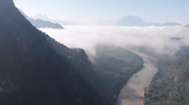 Hava aracı Laos 'taki Nam Ou Nehri üzerinde uçuyor, sabah sisi ve bulutları, Nong Khiaw Muang Ngoi dramatik manzara manzarası manzaralı tepe uçurumu, Güney Doğu Asya' daki seyahat noktası