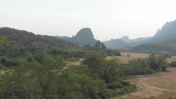 飞越稻田独特的山谷风景秀丽的悬崖峭壁岩石峰顶热带丛林迷人的风景和传统村庄在老挝北部 受欢迎的目的地亚洲 — 图库视频影像