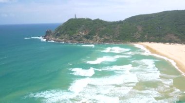 Manzaralı tropik körfez manzarası, Bai Mon muhteşem altın plajı ve kum tepeleri mavi dalgalı deniz. Vietnam 'ın en doğusundaki deniz feneri, Da Nang ve Nha Trang arasında Phu Yen vilayeti..