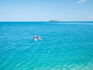 Mercan resifinde şnorkelle yüzen kadın tropik Karayip denizinde, turkuaz mavi suda. Endonezya Wakatobi takımadaları, deniz milli parkı, turist dalış merkezi