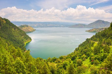 Toba Gölü ve Sumatra Endonezya 'dan Samosir Adası manzarası. Büyük volkanik kaldera suyla kaplı, geleneksel Batak köyleri, yeşil pirinç tarlaları, ekvatoral orman.