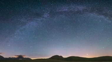 Campo Imperatore dağları üzerinde panoramik gece gökyüzü, Abruzzo, İtalya. Samanyolu galaksisi kavisi ve aydınlatılmış karavanın üzerindeki yıldızlar. Eşsiz tepelerde kamp yapma özgürlüğü.