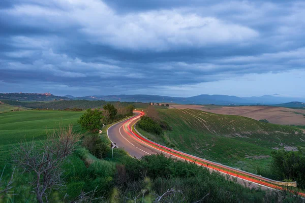 Światła Samochodowe Krętej Drodze Unikalnym Krajobrazie Wzgórza Toskanii Włochy Dramatyczne — Zdjęcie stockowe