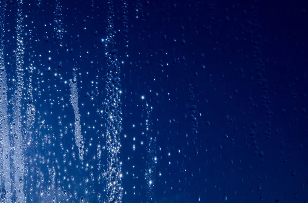Våt blått glas bakgrund med droppar och gnistor — Stockfoto