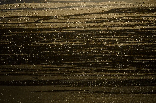 ıslak altın kahverengi cam arka plan damla ve sparks