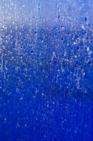 Sfondo di vetro blu bagnato con gocce e scintille — Foto Stock
