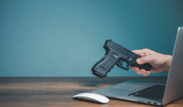 Buying handgun from online seller shop, Hands of seller sending handgun on computer to buying handgun person on website or social media with copy space.