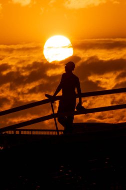 Silhouettes of construction workers on the background of the sunset sky with a huge disk of the sun. High quality photo