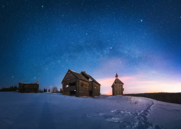 Milky Way Arc panorama and sky full of stars above old abandoned wooden houses in the winter night — Stok fotoğraf