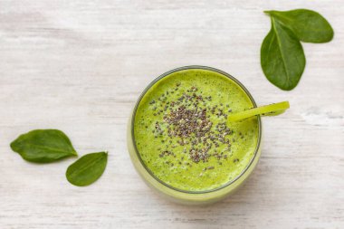 Ispanaklı smoothie. Sağlıklı beslenme ve beslenme, yiyecek ve içecek, vejetaryen, vejetaryen konsepti, sağlıklı yaşam tarzı. Organik malzemeli yeşil meyve püresi, ahşap masada sebzeler.. 