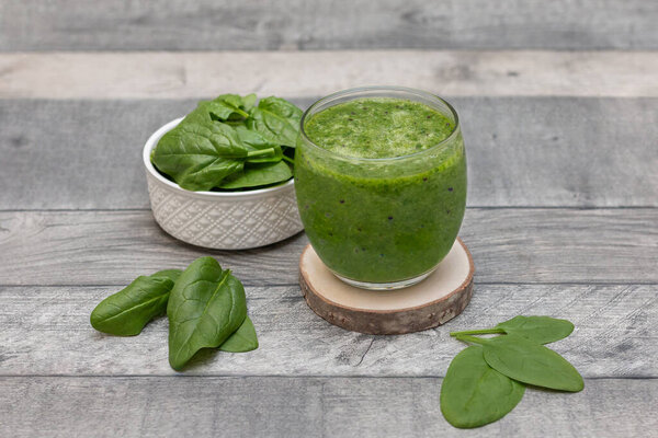 Spinach smoothie. Healthy dieting and nutrition, food and drink, vegan, vegetarian concept, healthy lifestyle. Green smoothie with organic ingredients, vegetables on a wooden table. 