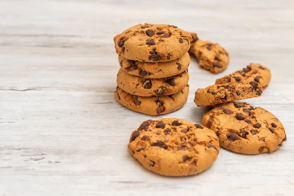 Beyaz ahşap masada sütlü çikolatalı kurabiyeler. Çikolata parçacıklı kurabiye.. 
