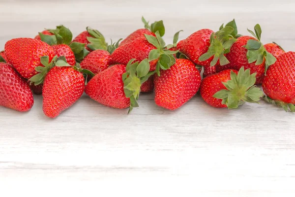 Beyaz ahşap arka planda taze çilekler. Uzayın en üst görüntüsü. Doğa meyvesi kavramı ve sağlıklı beslenme.