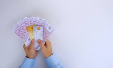 Beyaz arka planda kağıt para tutan kadın elleri.
