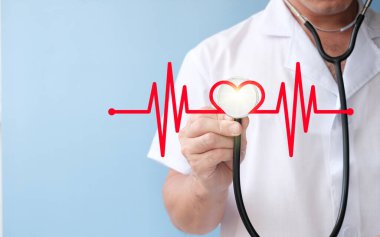 hand holding stethoscope and heart on blue background. health and medical concept.