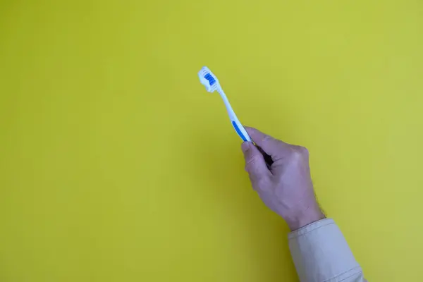 Hand Holding Toothbrush Toothpaste Yellow Background — Stock Photo, Image