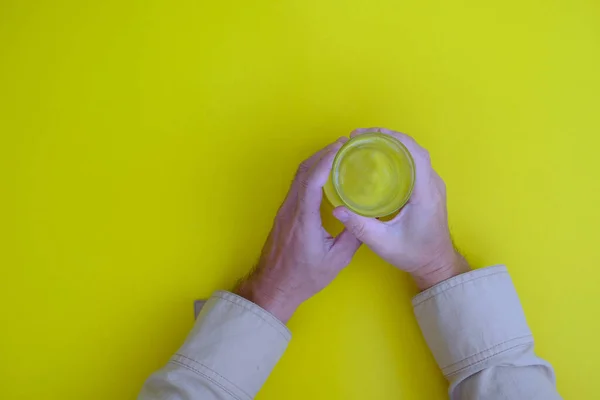 Hand Holding Glass Yellow Background — ストック写真