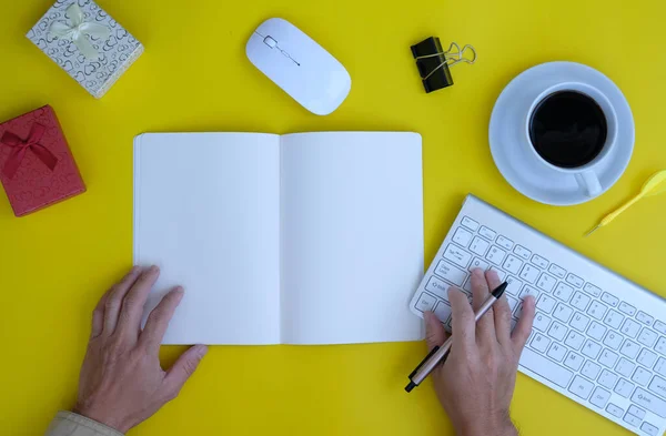 top view of keyboard, office supplies and notebook on yellow background