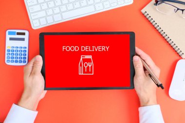 business concept. hand holding a tablet with text: food delivery