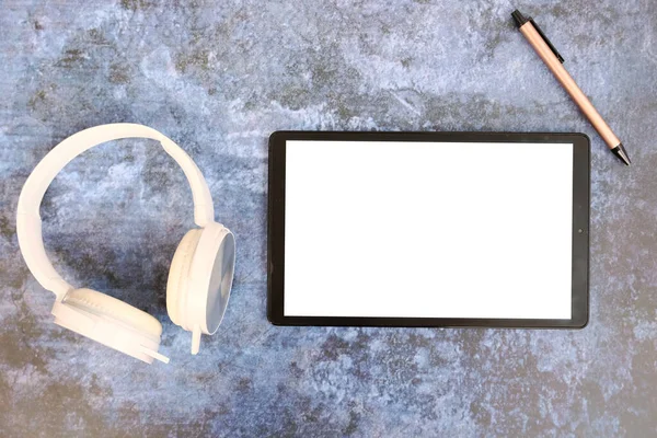 tablet with blank screen and digital device on table