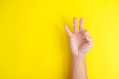 hand gesture OK on yellow background 
