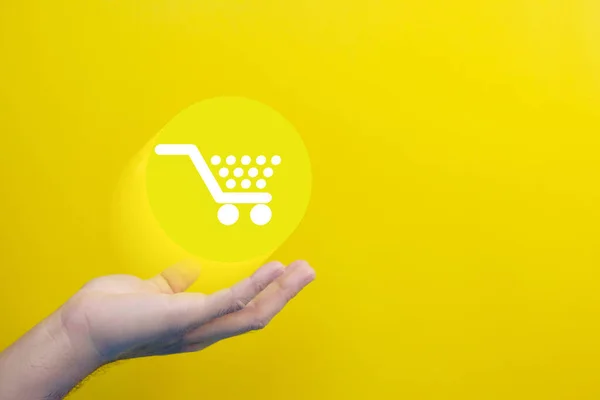 Hand Holding Shopping Cart Yellow Background —  Fotos de Stock