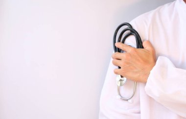 Steteskoplu bir doktor ve bir hastanenin arka planında beyaz önlük..