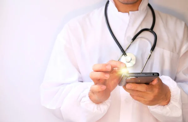 young doctor using mobile phone and stethoscope