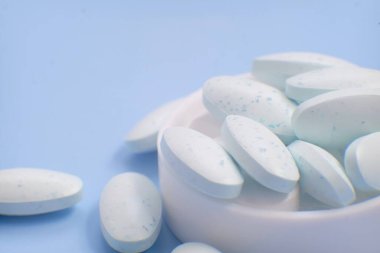 mavi zemin üzerine beyaz ve mavi hap.