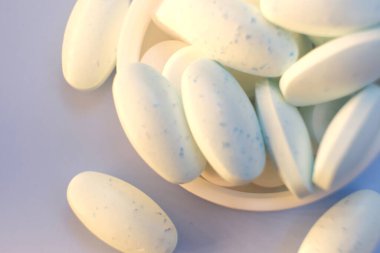 mavi zemin üzerine beyaz ve mavi hap.