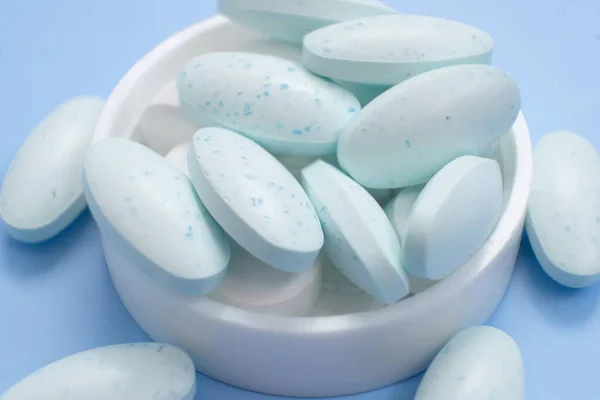 white and blue pills on blue background.