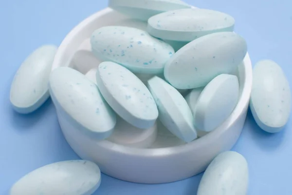 white and blue pills on blue background.