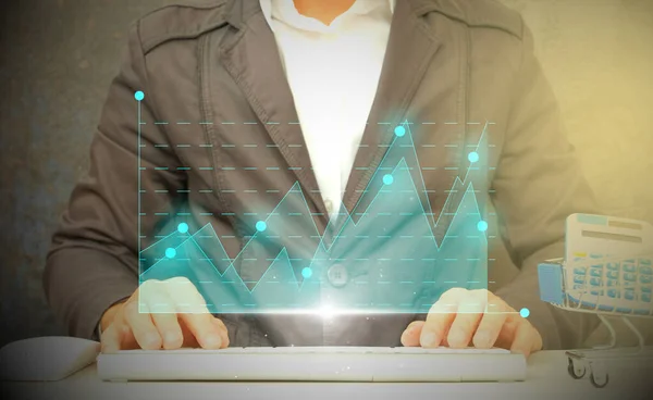 İş adamı elinde içinde finansal semboller ve grafikler olan bir tablet bilgisayar tutuyor.