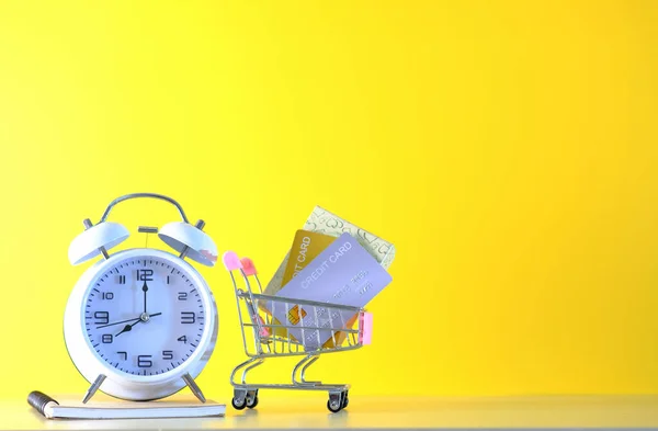 Carrito Compras Con Despertador Tarjeta Crédito Sobre Fondo Amarillo —  Fotos de Stock