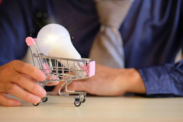 Geschäftsmann Hält Einkaufswagen Mit Glühbirne Der Hand — Stockfoto